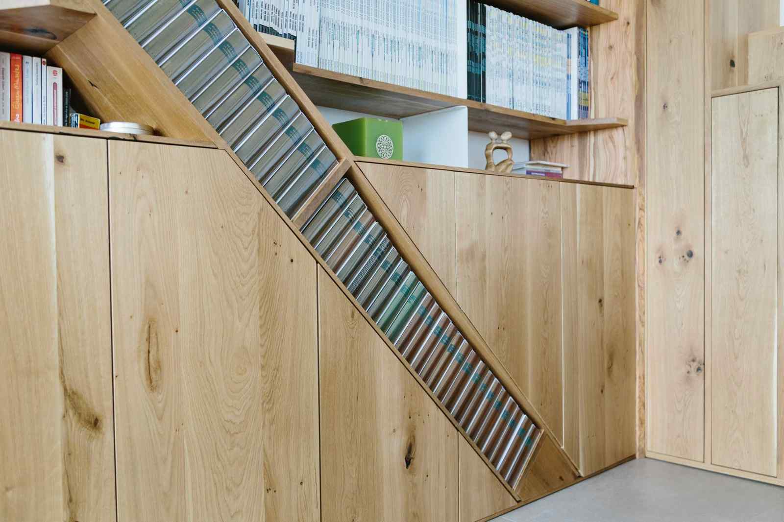 Detaliu din biblioteca din lemn de stejar cu corpurile de depozitare și raft înclinat