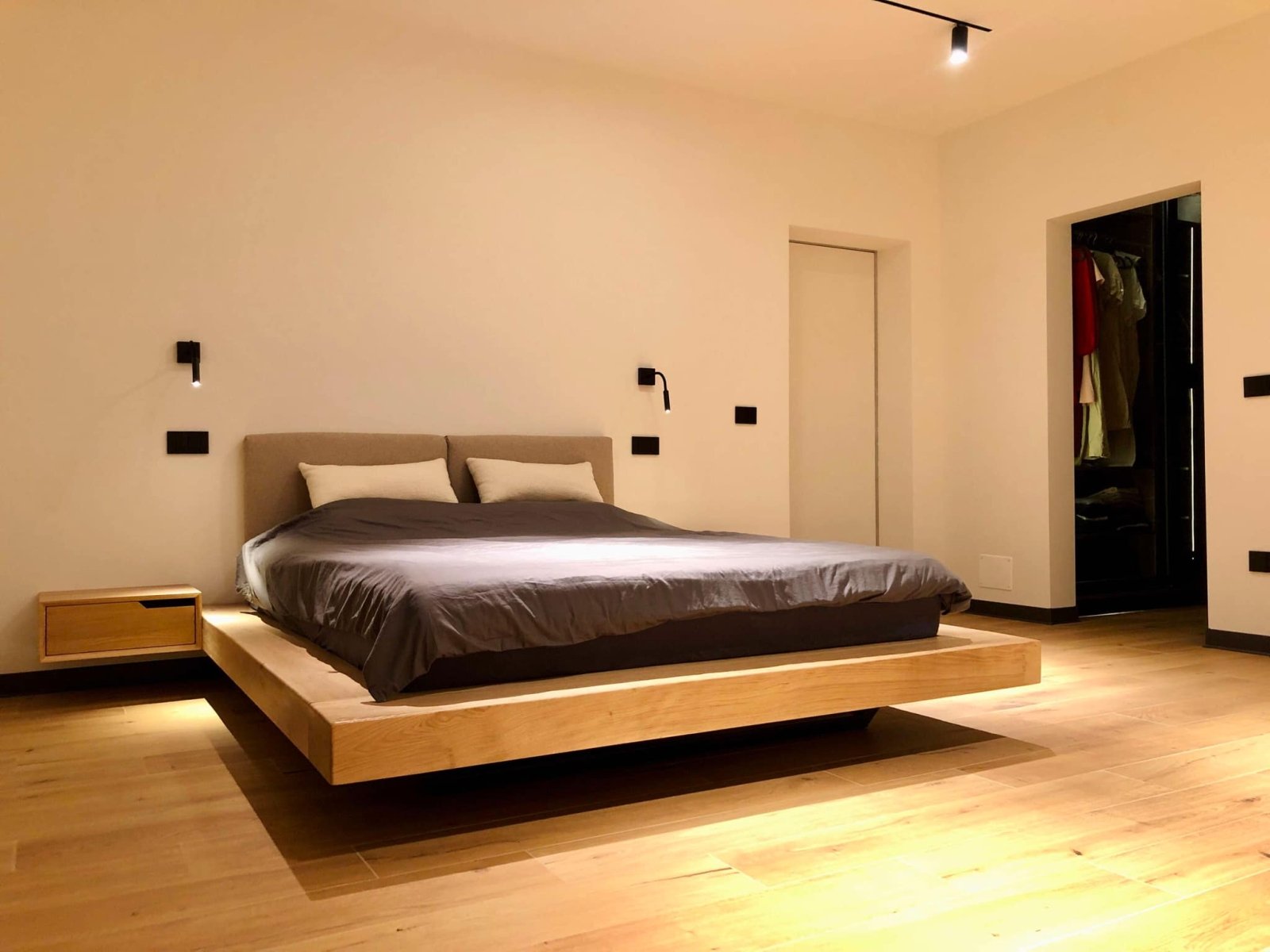 Oak platform bed with wall mounted nightstands and upholstered headrest