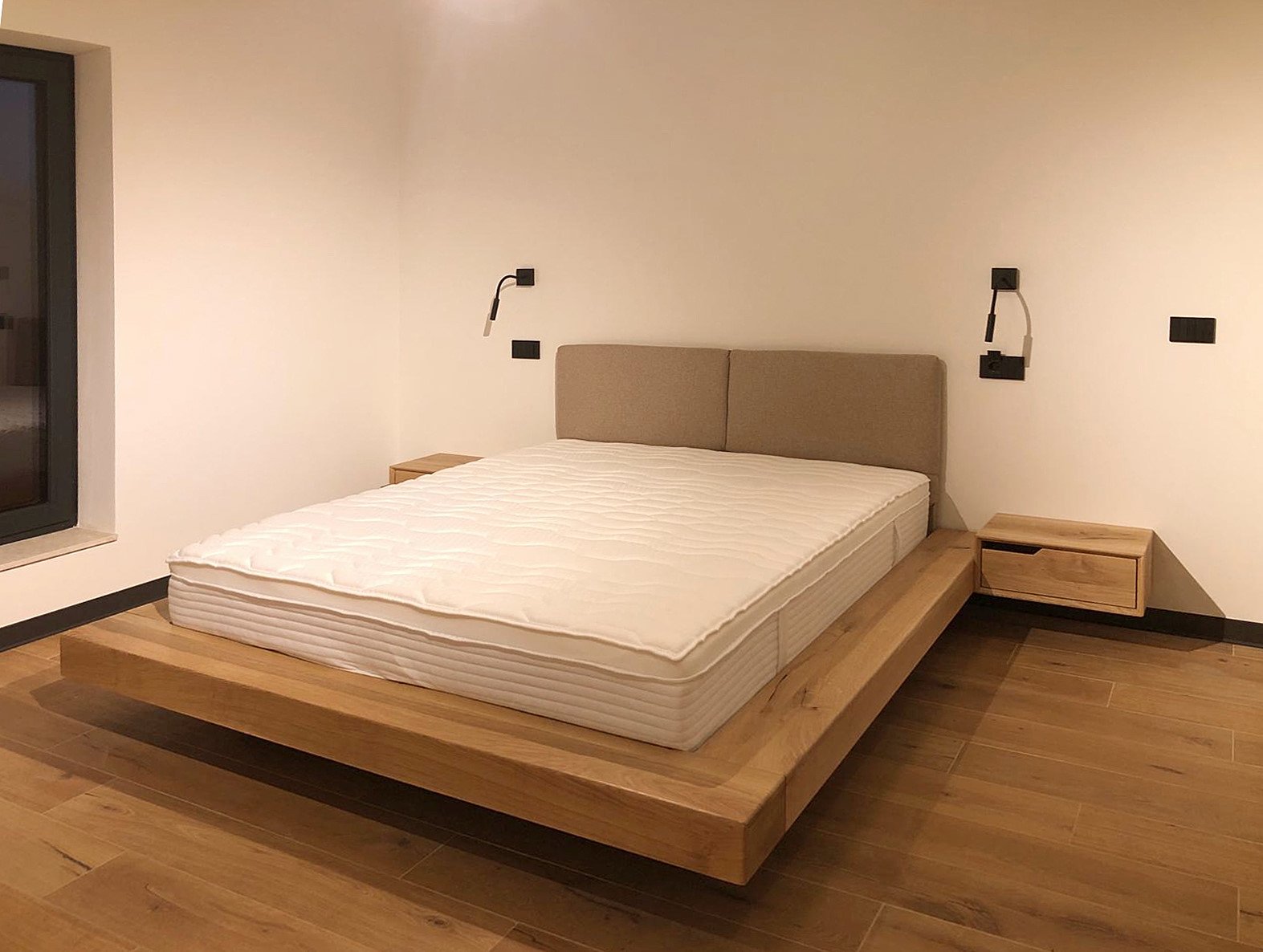 Bedroom view with bed frame in solid oak and wall mounted light features and nightstand