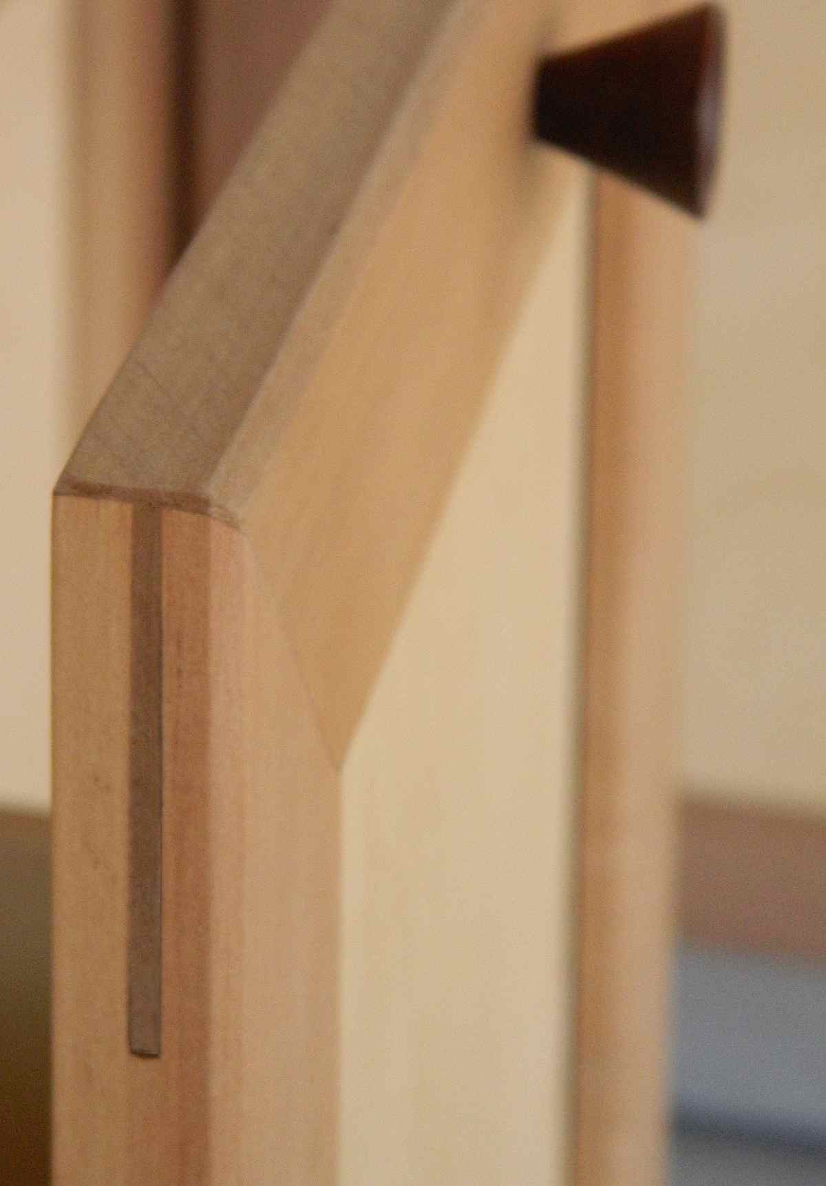 vedere de aproape cu imbinare contrastanta intre cep si scobitura intr-un front de mobila cu rama si tablie