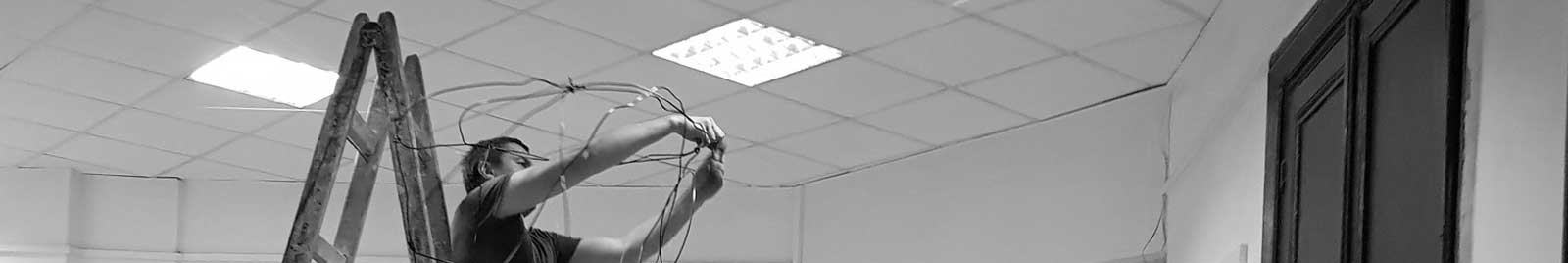 technician on a ladder, installing artworks